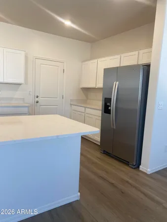 a kitchen with kitchen island a counter top space wooden floor and stainless steel appliances