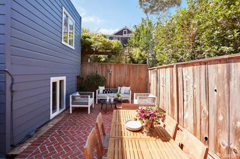 a view of a patio with table and chairs and potted plants