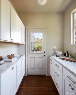 a kitchen with stainless steel appliances white cabinets and a window