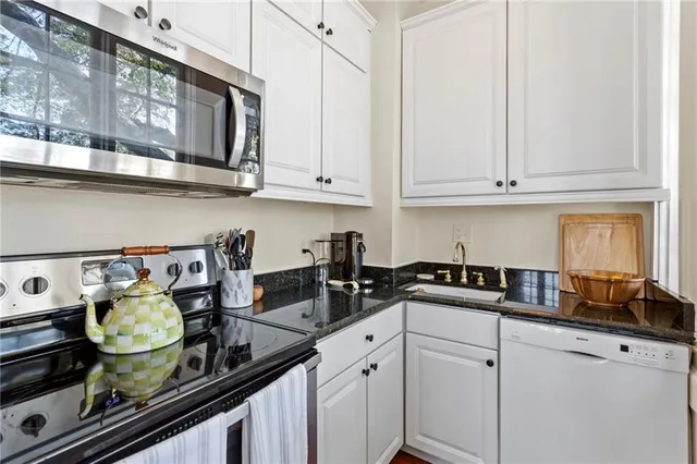 a kitchen with stainless steel appliances granite countertop a sink stove and cabinets