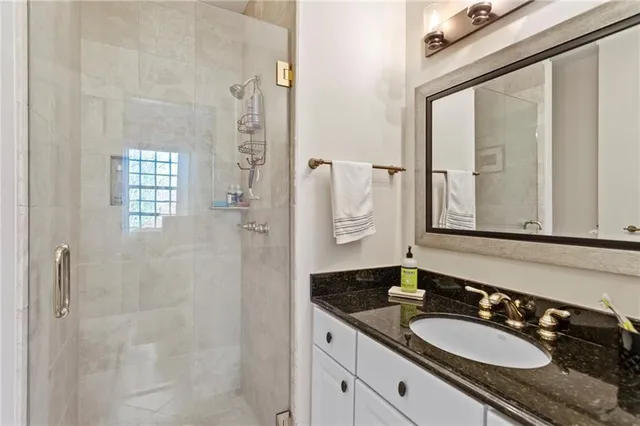 a bathroom with a granite countertop double vanity sink and mirror