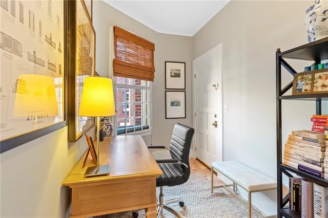 a view of a workspace with furniture and a window