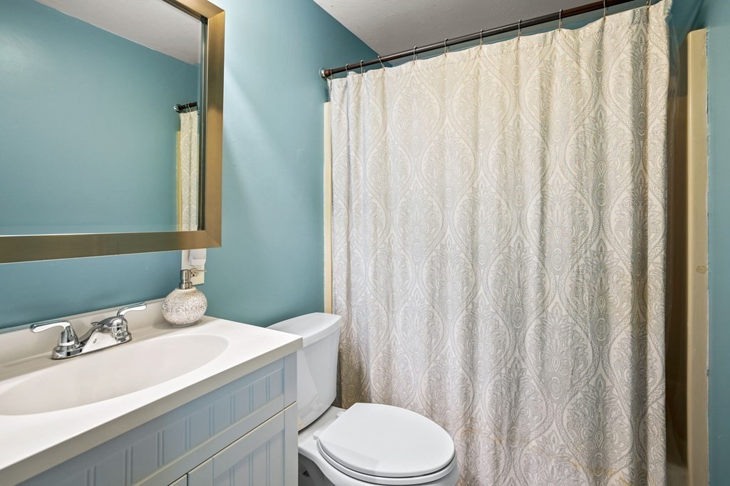 225 Skunknet Road Barnstable, MA 02632 - Photo 12 of 27 a bathroom with a sink a toilet and shower curtain