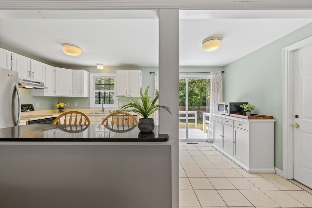 225 Skunknet Road Barnstable, MA 02632 - Photo 7 of 27 a kitchen with stainless steel appliances granite countertop a refrigerator a sink a stove and white cabinets