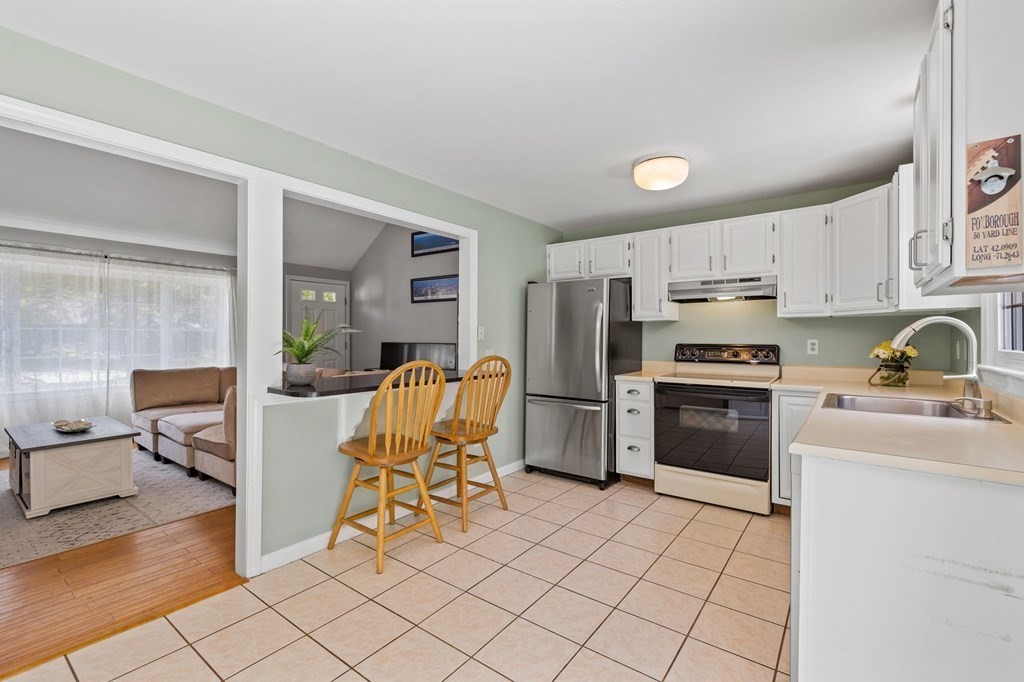 225 Skunknet Road Barnstable, MA 02632 - Photo 9 of 27 a kitchen with stainless steel appliances a refrigerator and a stove top oven