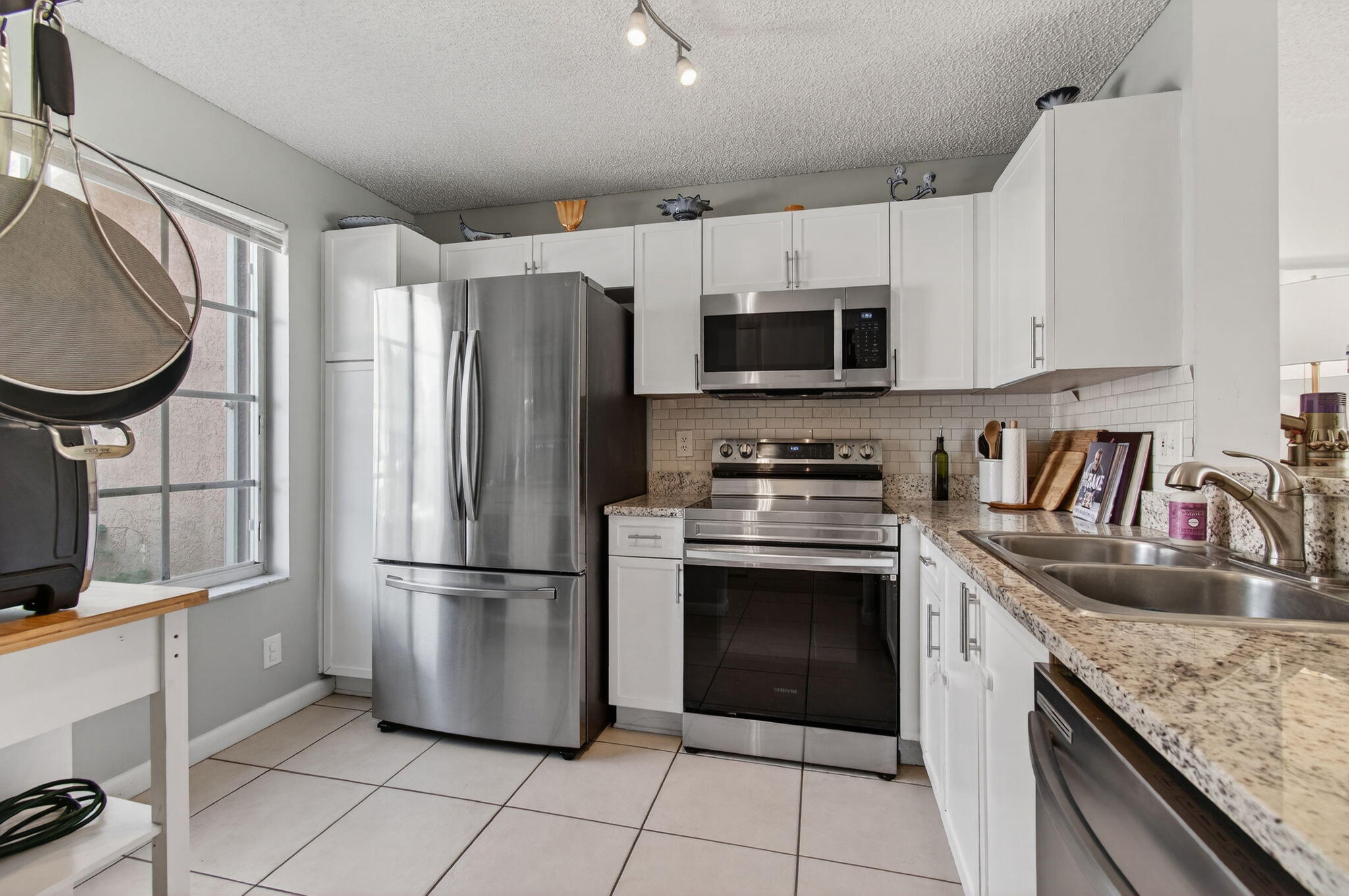 9931 Kamena Circle Boynton Beach, FL 33436 - Photo 10 of 37 a kitchen with granite countertop a refrigerator sink and cabinets
