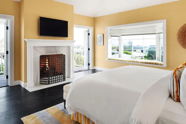 a view of a livingroom with wooden floor and a fireplace