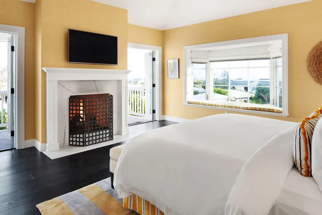 a view of a livingroom with wooden floor and a fireplace