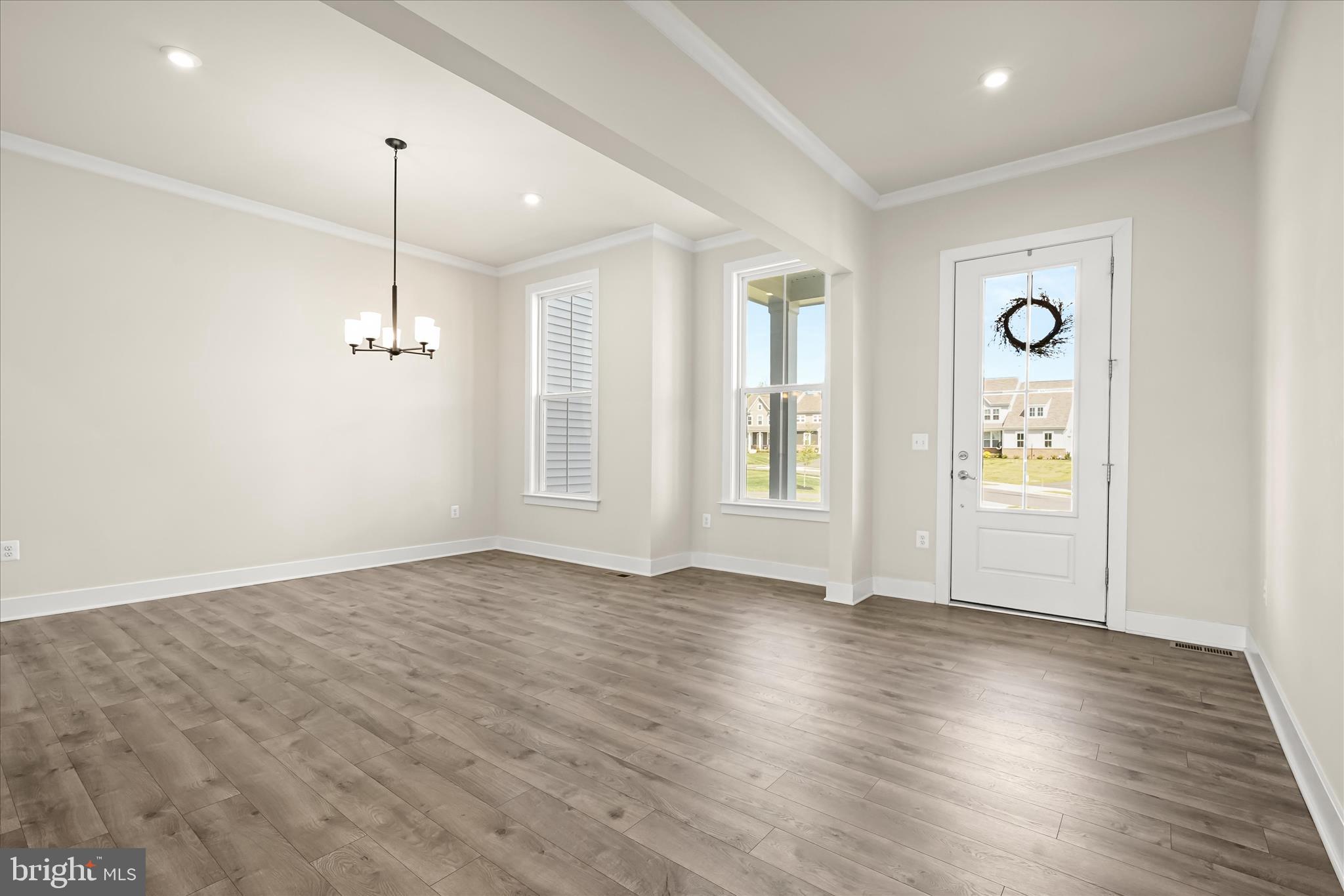 7306 Sugar Magnolia Loop Gainesville, VA 20155 - Photo 11 of 71 a view of an empty room with wooden floor and a window