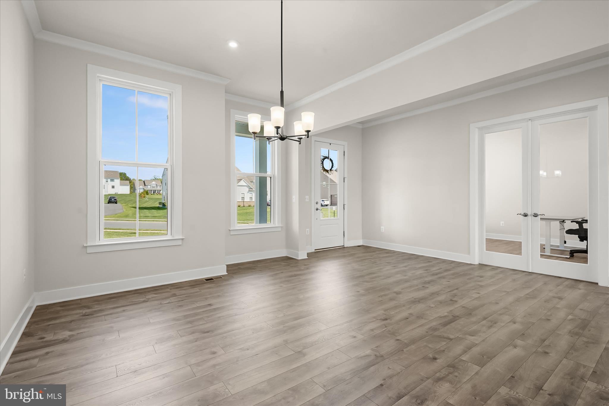 7306 Sugar Magnolia Loop Gainesville, VA 20155 - Photo 13 of 71 a view of an empty room with wooden floor and a window