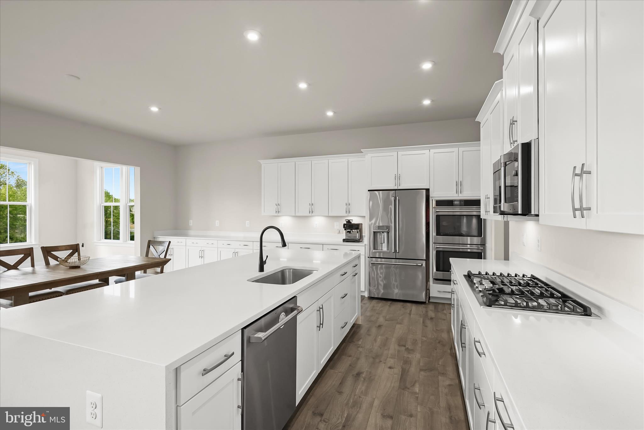 7306 Sugar Magnolia Loop Gainesville, VA 20155 - Photo 18 of 71 a kitchen with refrigerator a sink and white cabinets