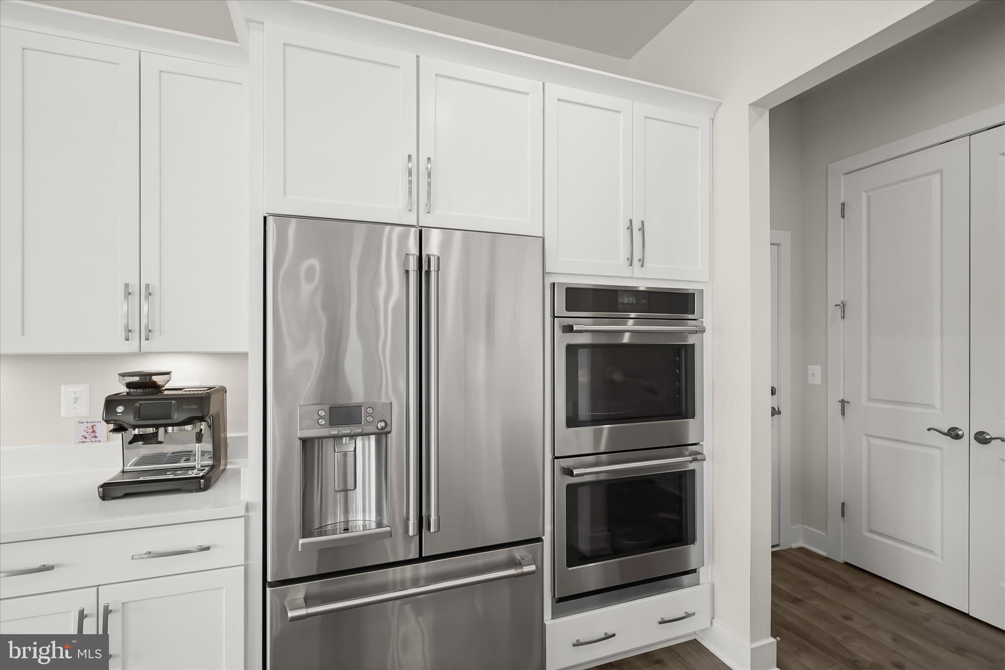 7306 Sugar Magnolia Loop Gainesville, VA 20155 - Photo 21 of 71 a kitchen with stainless steel appliances a refrigerator stove and cabinets