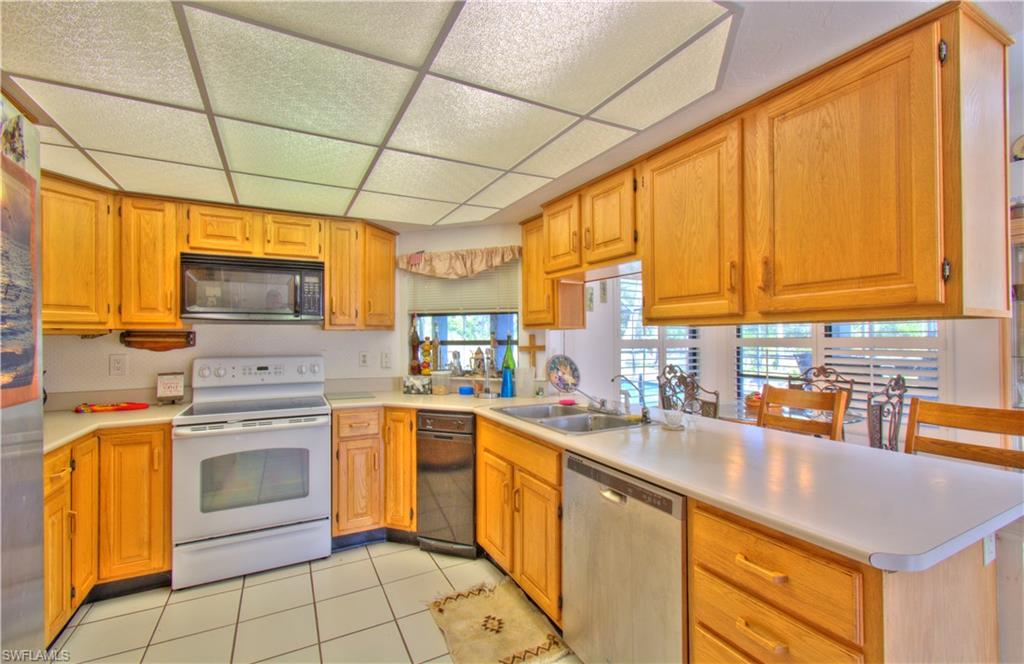 2600 Garland Road Naples, FL 34117 - Photo 13 of 34 a kitchen with stainless steel appliances granite countertop a sink a stove and cabinets