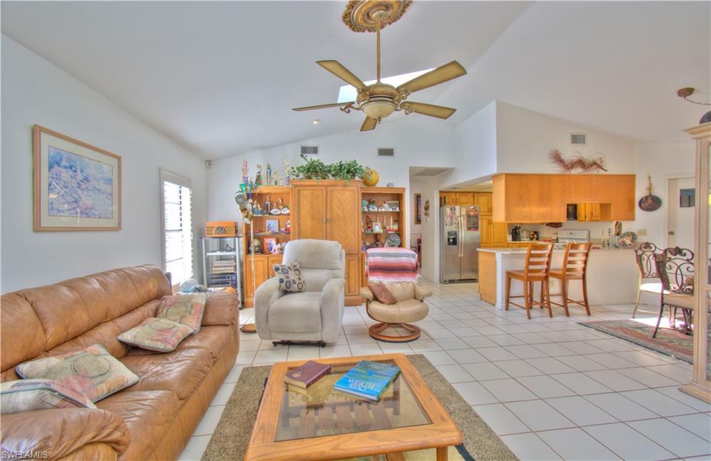 2600 Garland Road Naples, FL 34117 - Photo 18 of 34 a living room with furniture a rug kitchen view and a chandelier