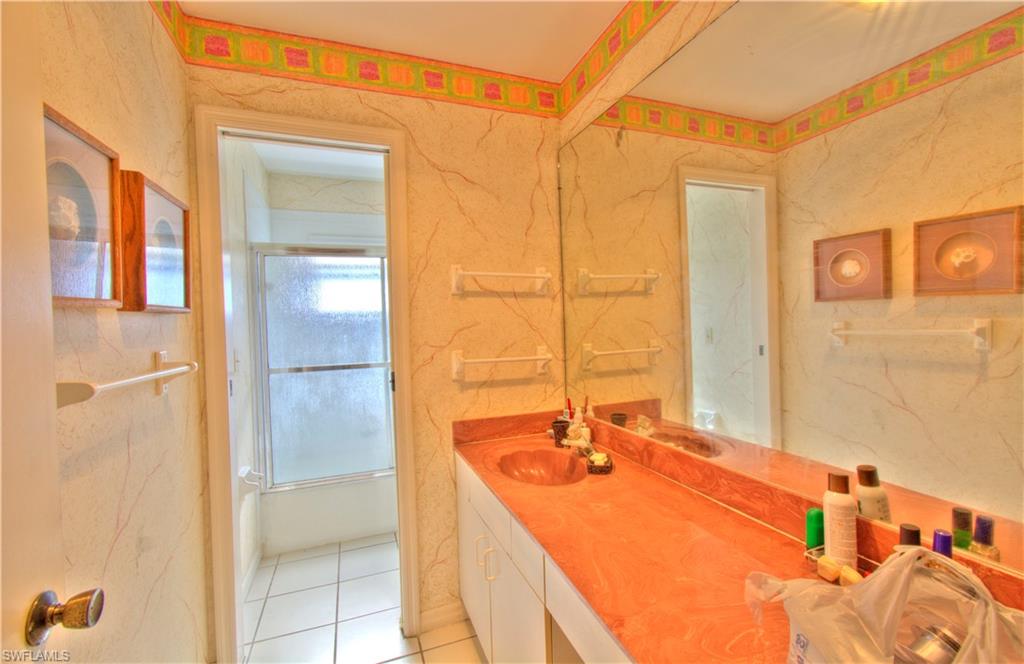 2600 Garland Road Naples, FL 34117 - Photo 22 of 34 a bathroom with a tub sink and mirror
