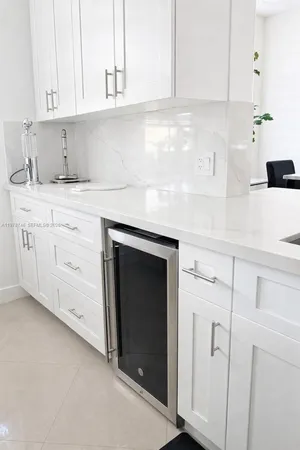 a kitchen with granite countertop white cabinets and white appliances