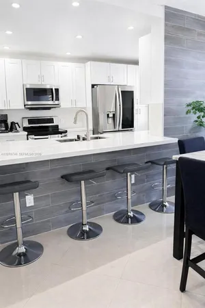a kitchen with sink and chairs