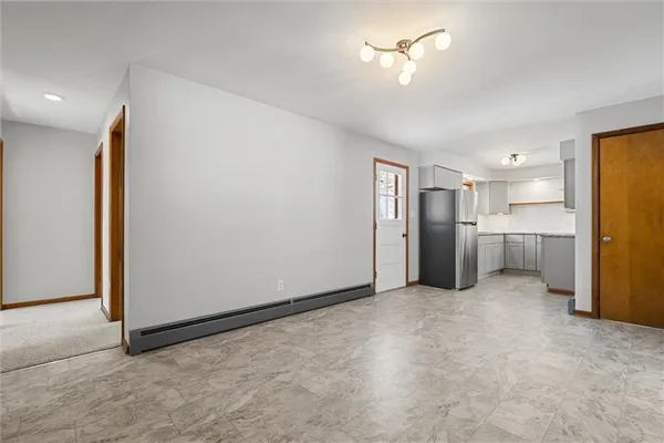 a view of a kitchen with a refrigerator and a stove top oven