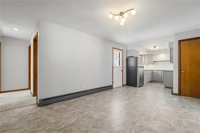 a view of a kitchen with a refrigerator and a stove top oven