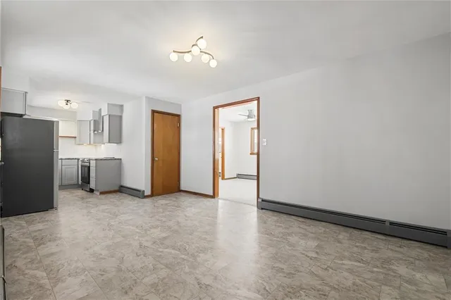 a view of an empty room with a kitchen