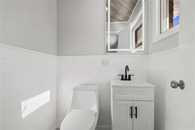 a bathroom with a sink a toilet and a mirror