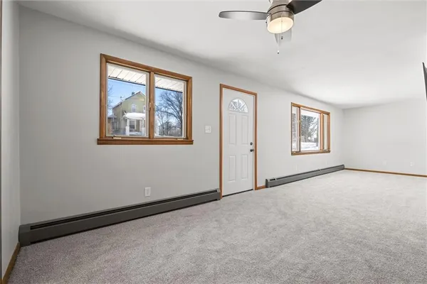 an empty room with windows and fan