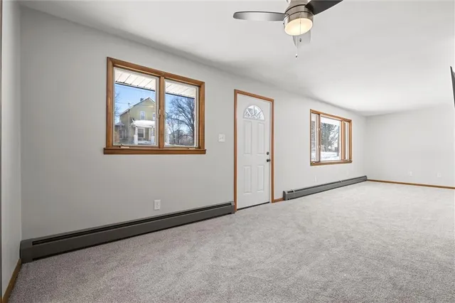 an empty room with windows and fan