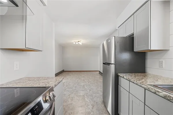 a kitchen with stainless steel appliances granite countertop a refrigerator and a stove
