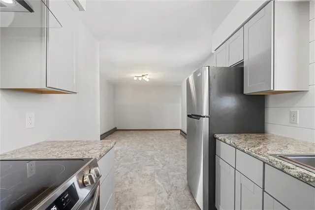 a kitchen with stainless steel appliances granite countertop a refrigerator and a stove
