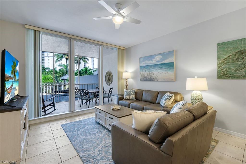 460 Launch Circle, Unit 202 Naples, FL 34108 - Photo 4 of 34 a living room with furniture and a flat screen tv