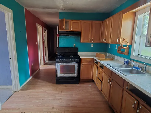 a kitchen with stainless steel appliances a sink stove and cabinets