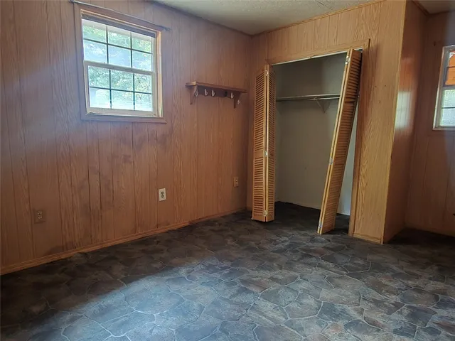 an empty room with closet and windows