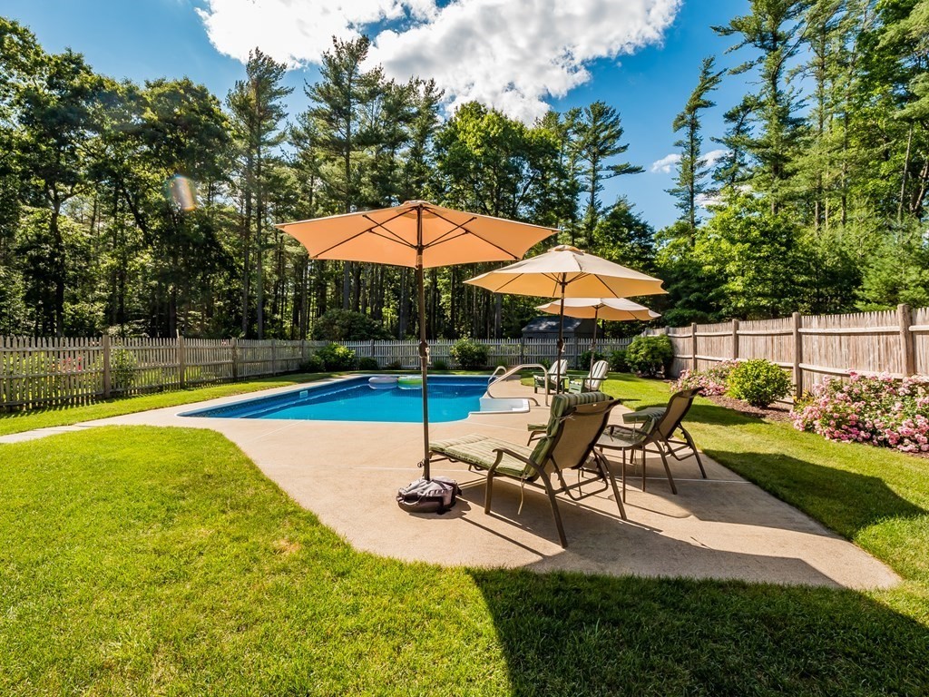 76 Williams Way Rochester, MA 02770 - Photo 32 of 42 a view of a swimming pool with a table and chairs under an umbrella