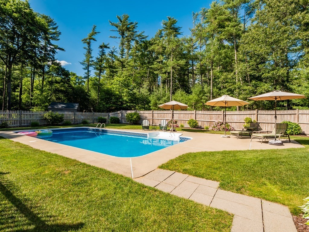 76 Williams Way Rochester, MA 02770 - Photo 33 of 42 a view of a swimming pool with lawn chairs under an umbrella