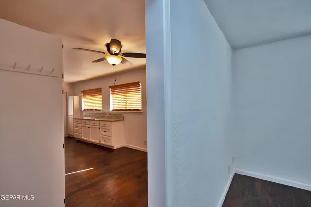 a view of an empty room with wooden floor
