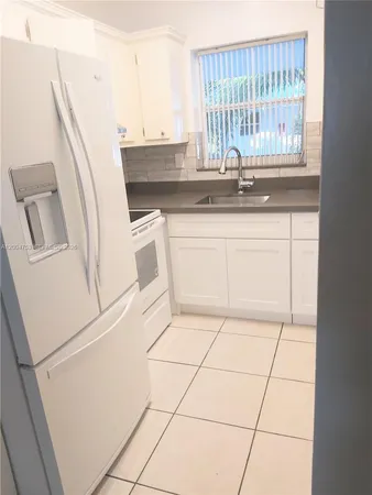 a kitchen with a sink a microwave and a refrigerator