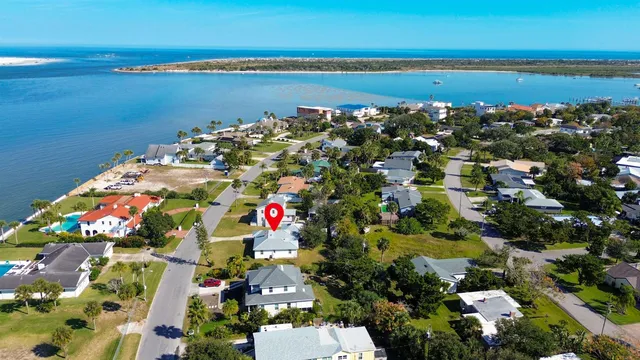 an aerial view of a house with a yard and large trees