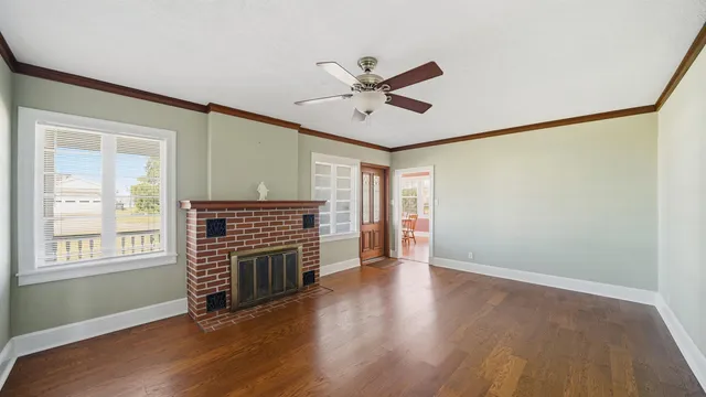 a view of an empty room with wooden floor