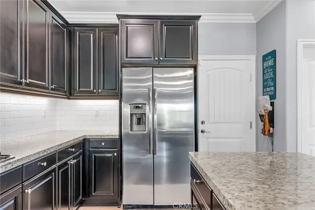 a kitchen with granite countertop a refrigerator and a sink