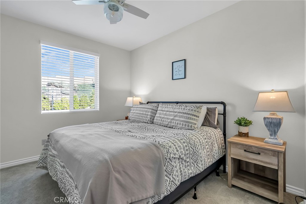16568 Fleur Boulevard Riverside, CA 92503 - Photo 17 of 48 a bedroom with a bed a chandelier and a window