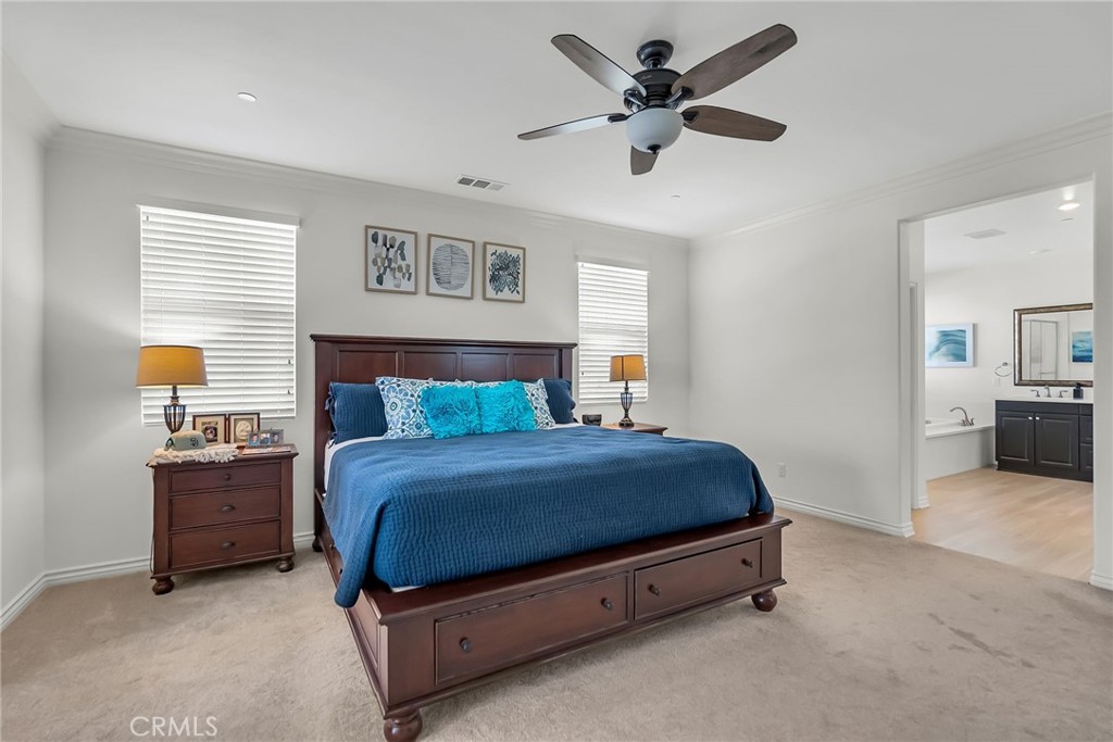 16568 Fleur Boulevard Riverside, CA 92503 - Photo 29 of 48 a spacious bedroom with a bed and a chandelier
