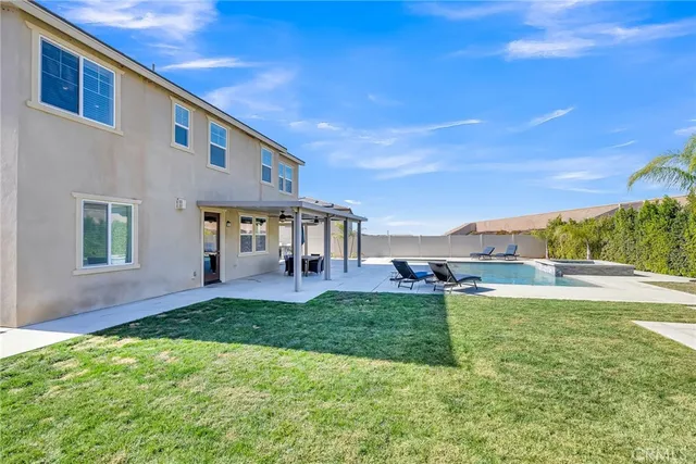 a view of a house with backyard and sitting area