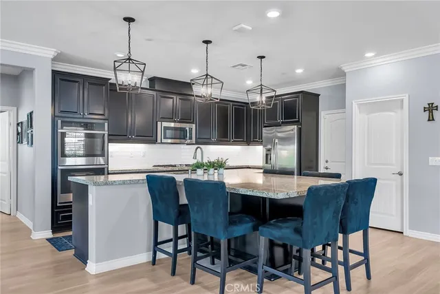 a kitchen with stainless steel appliances granite countertop a kitchen island a table and chairs