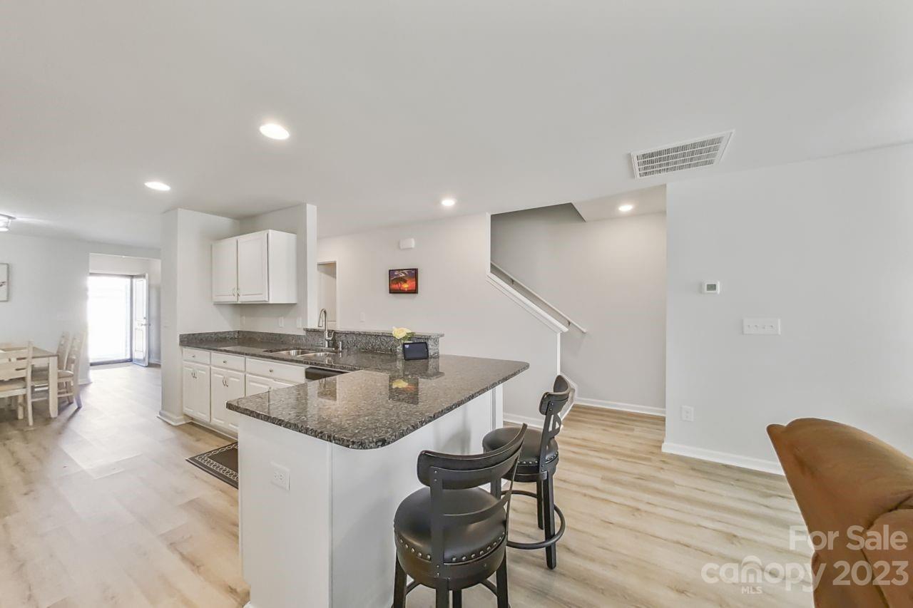 200 Windfall Road Blythewood, SC 29016 - Photo 7 of 20 a kitchen with stainless steel appliances granite countertop a stove a sink a dining table and chairs with wooden floor