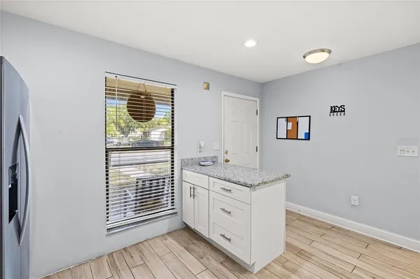 a bathroom with a granite countertop sink and a window