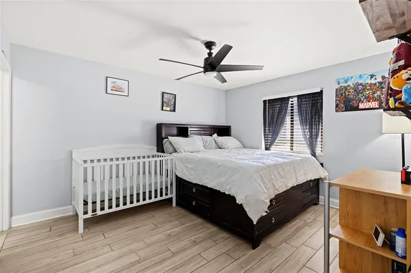 a bedroom with a bed and a ceiling fan