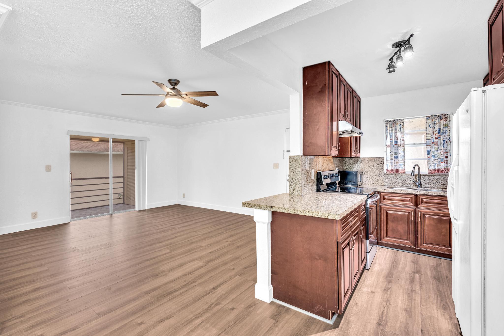 1291 Northwest 13th Street, Unit 445D Boca Raton, FL 33486 - Photo 11 of 50 a kitchen with stainless steel appliances granite countertop a stove a sink dishwasher and a refrigerator with wooden floor