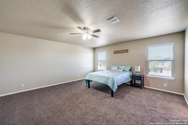a spacious bedroom with a bed and a chandelier