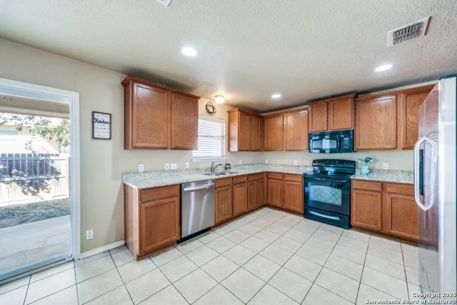 a kitchen with stainless steel appliances granite countertop a stove sink and cabinets