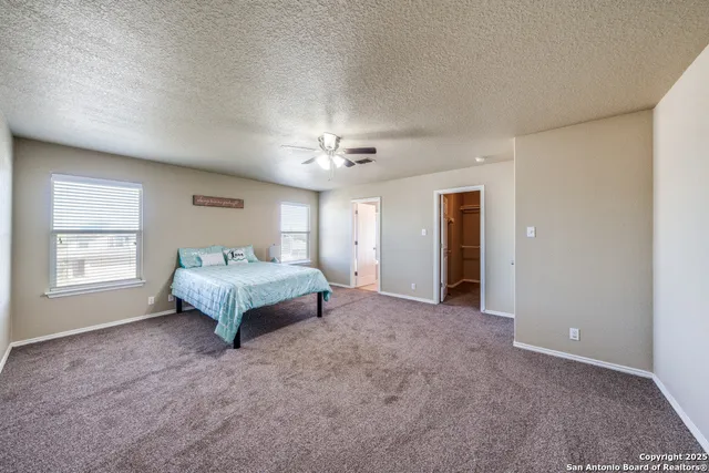 a spacious bedroom with a bed and a chandelier